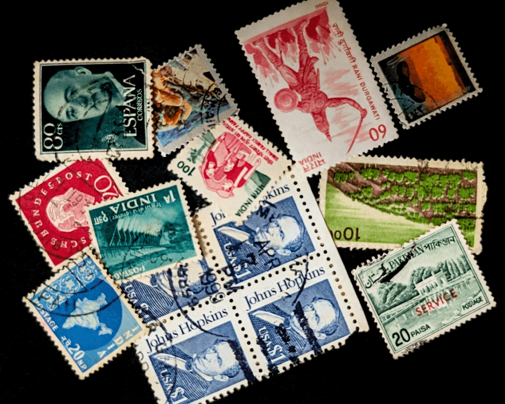 about page 2 Childhood stamp collection featuring vintage postage stamps from India, USA, Spain, and Pakistan, fanned out on a dark background