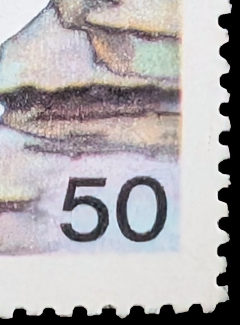 Macro detail of the 1986 Children's Day stamp's lower left corner showing complete perforation teeth, unpainted paper margin and the vertical denomination