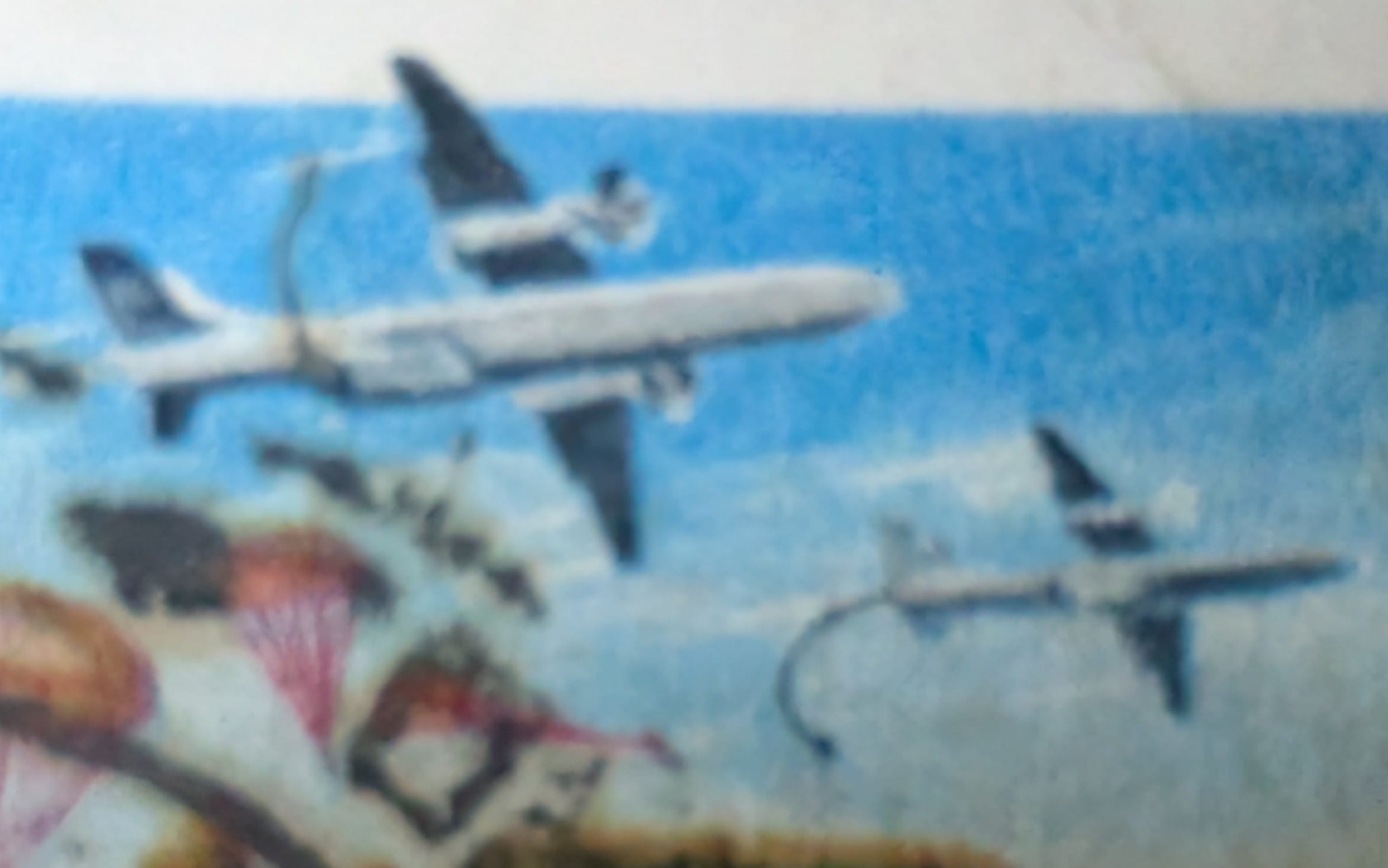 Macro detail of the 1993 India stamp showing a transport aircraft and a lighter jet above the drop zone.