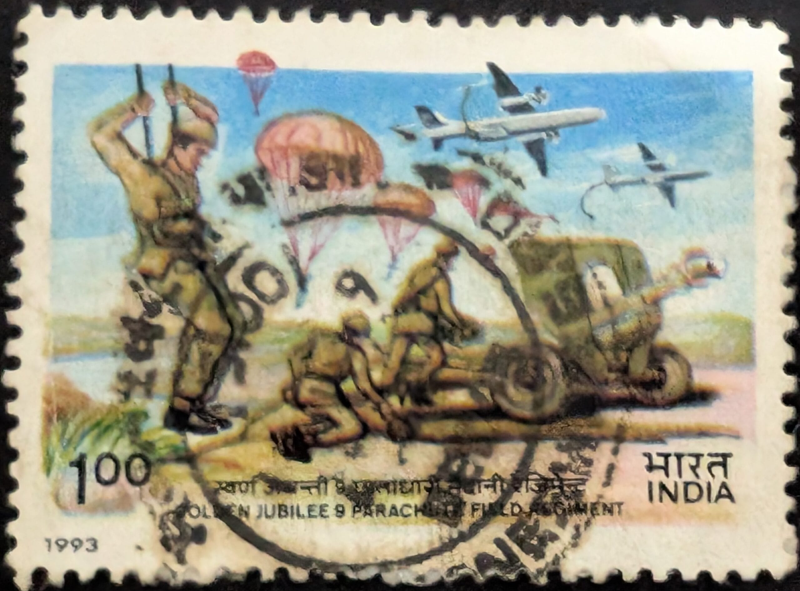 India 1993 Golden Jubilee stamp of the 9 Parachute Field Regiment, one rupee, showing a paratrooper, cargo parachutes, transport aircraft and a gun crew hauling a field gun.
