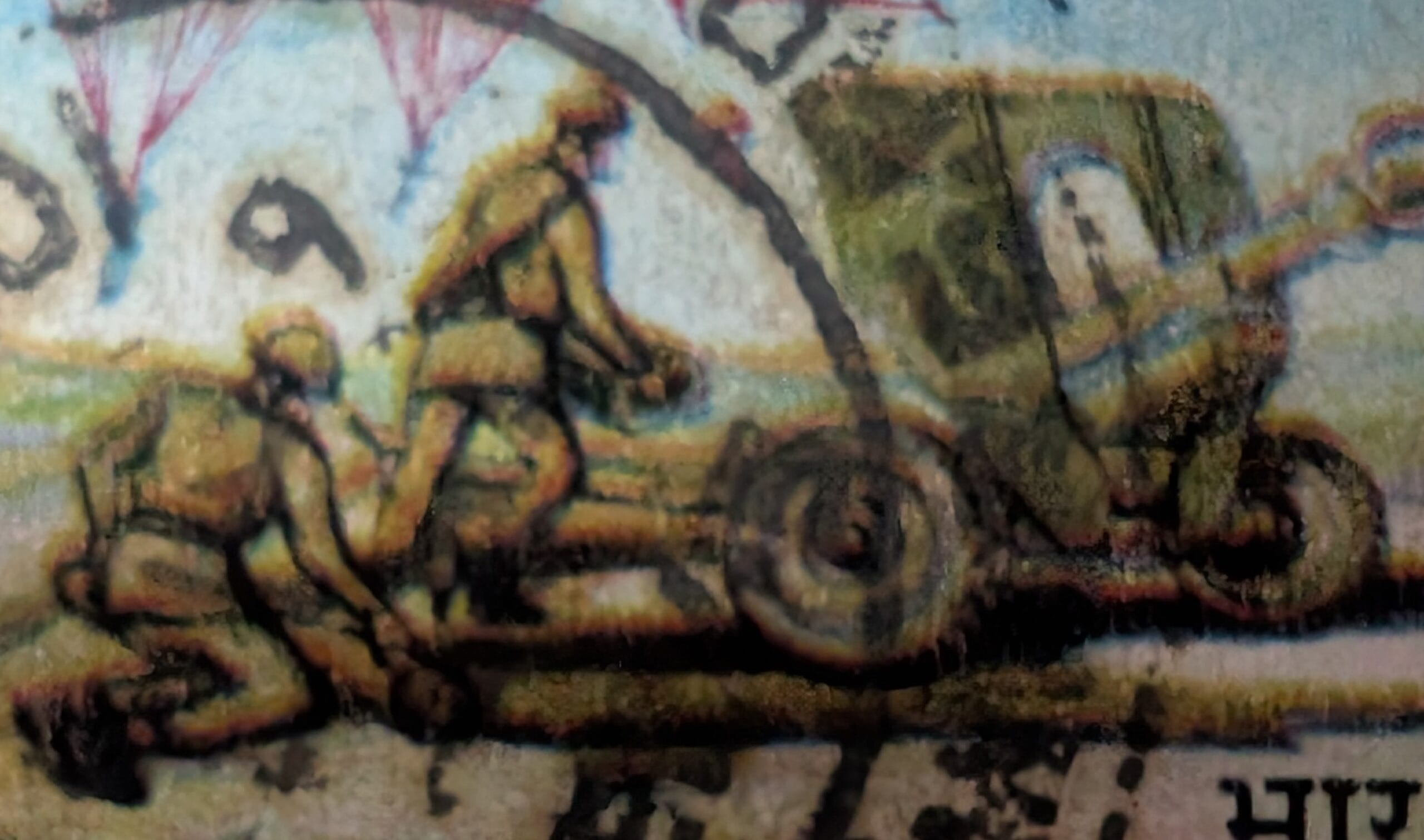Macro detail of the 1993 India stamp showing an airborne-artillery crew bent low to manhandle a wheeled field gun by its trail.