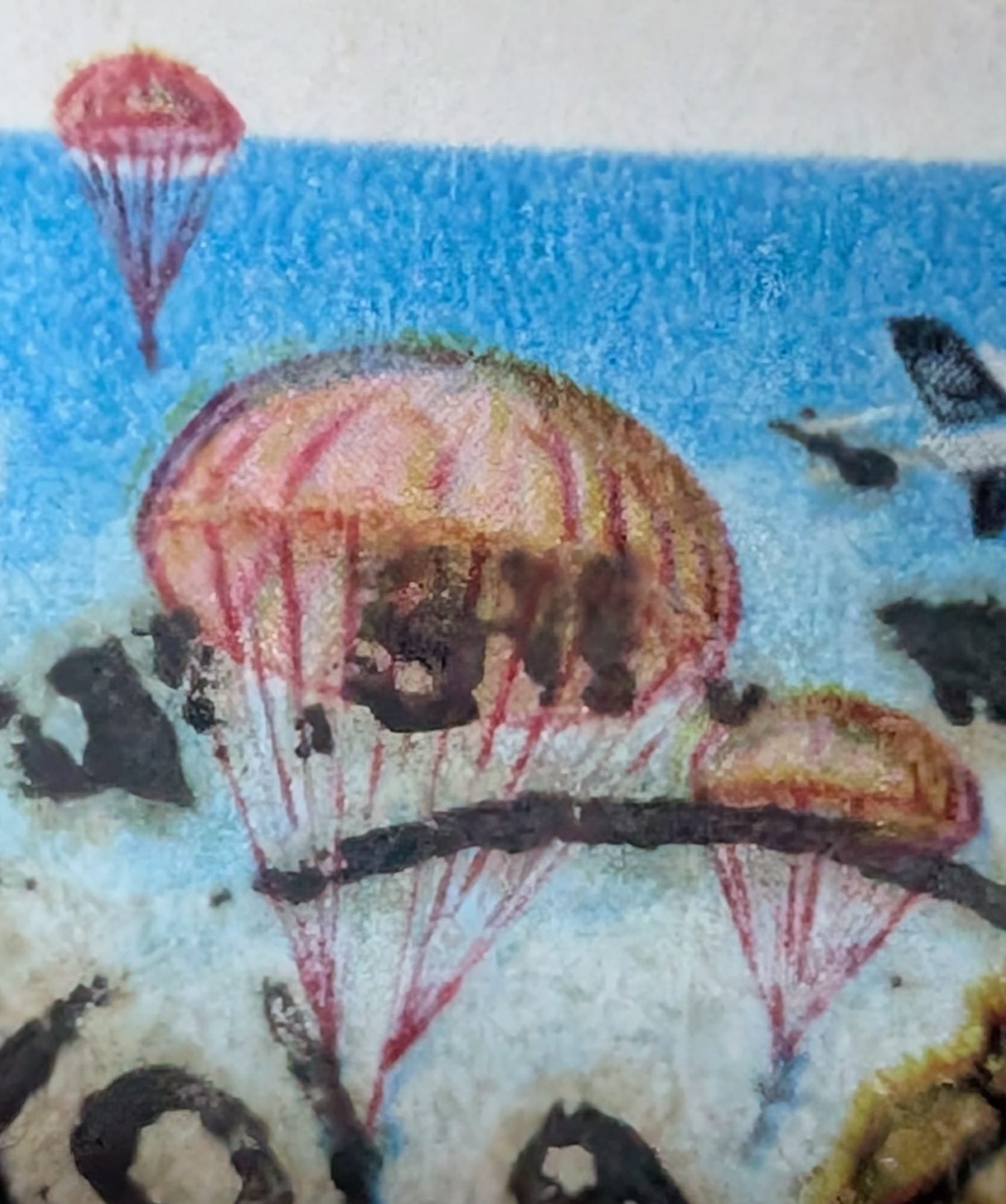 Macro detail of the 1993 India stamp showing open cargo parachutes descending with supply loads rather than men.