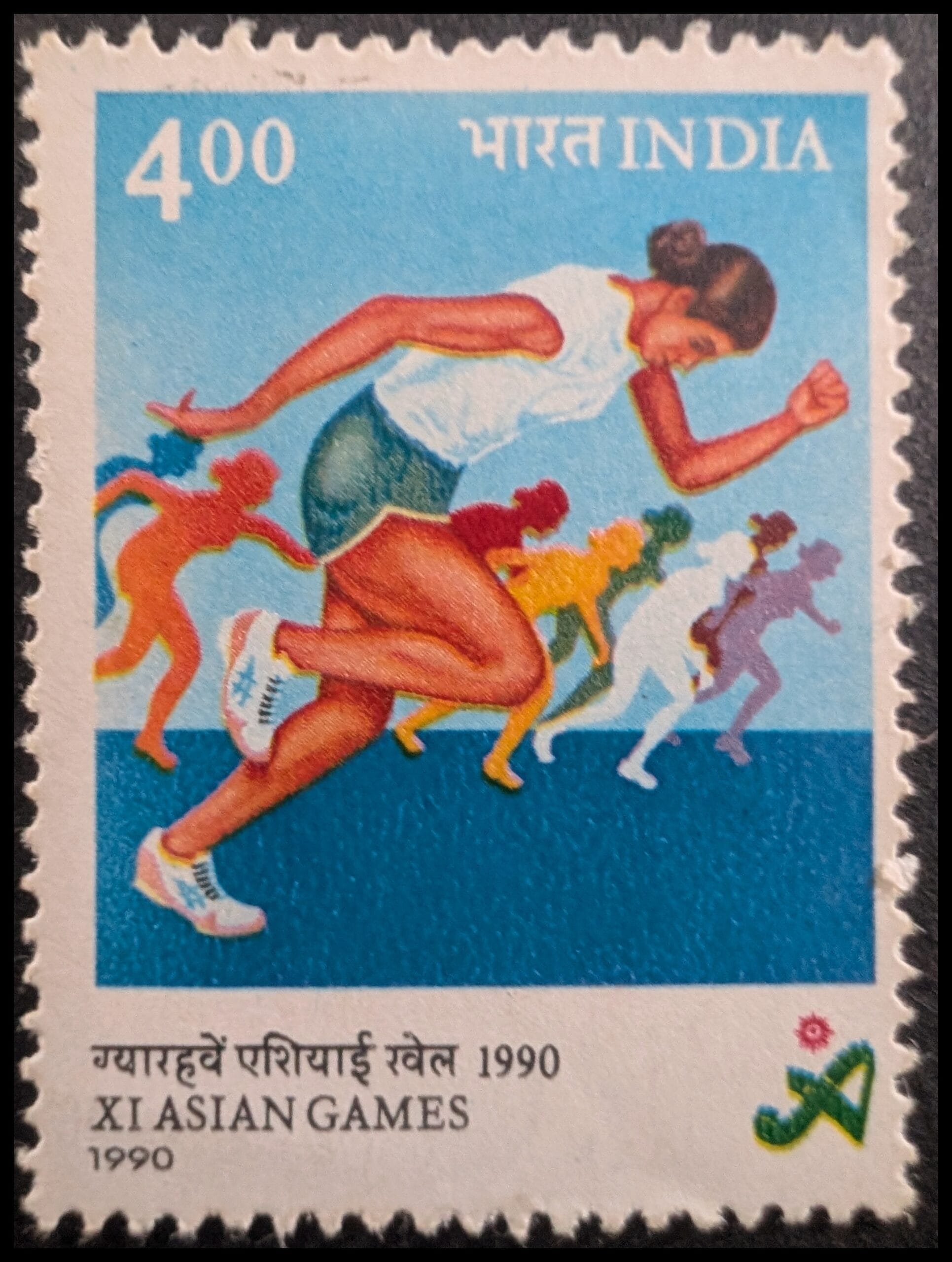 The complete 1990 India 4-rupee XI Asian Games stamp showing a lead sprinter and a receding row of coloured runners above the bilingual XI Asian Games caption