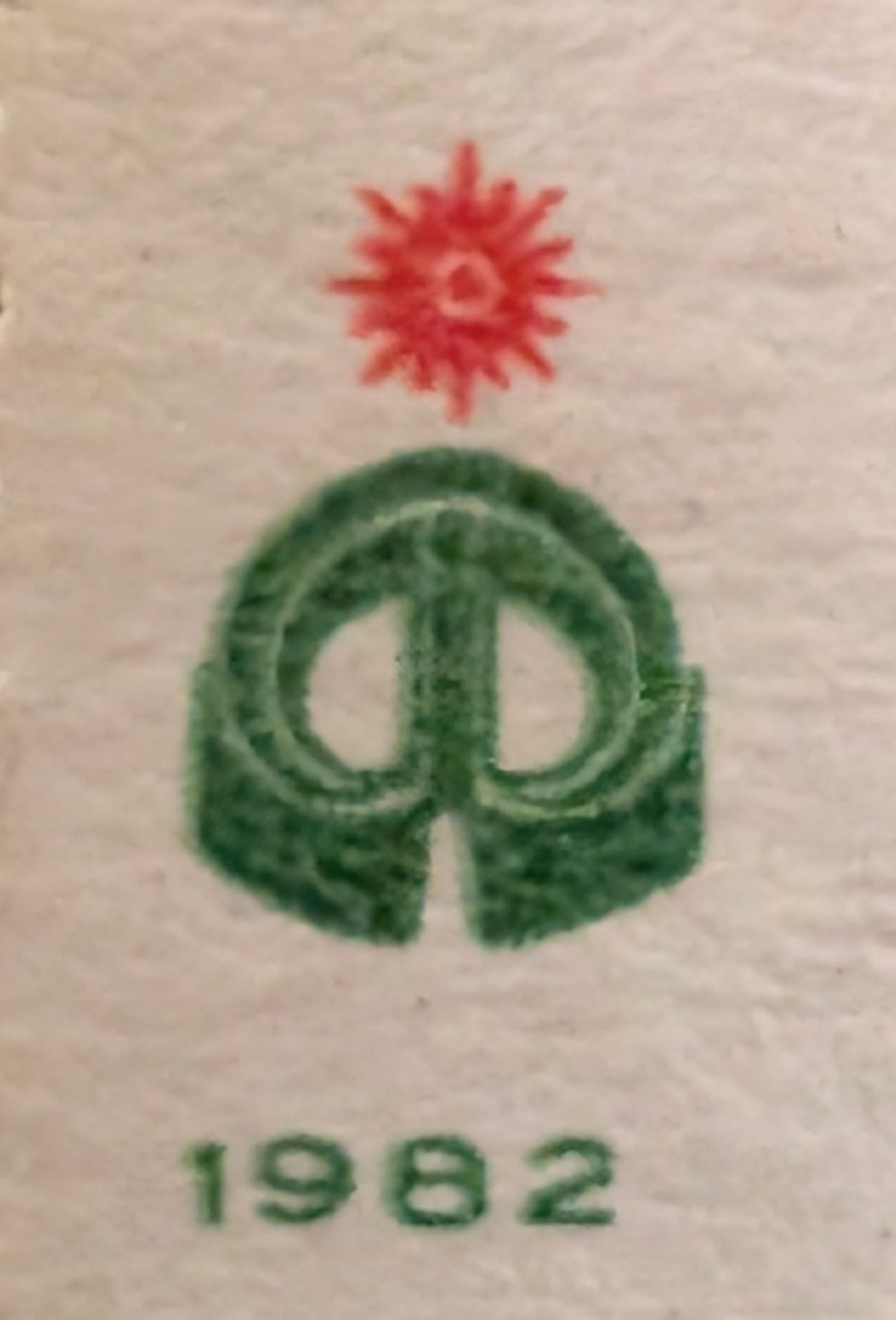 Macro of the green India Posts and Telegraphs emblem and small red sun device at the lower left of the 1982 India Asian Games stamp