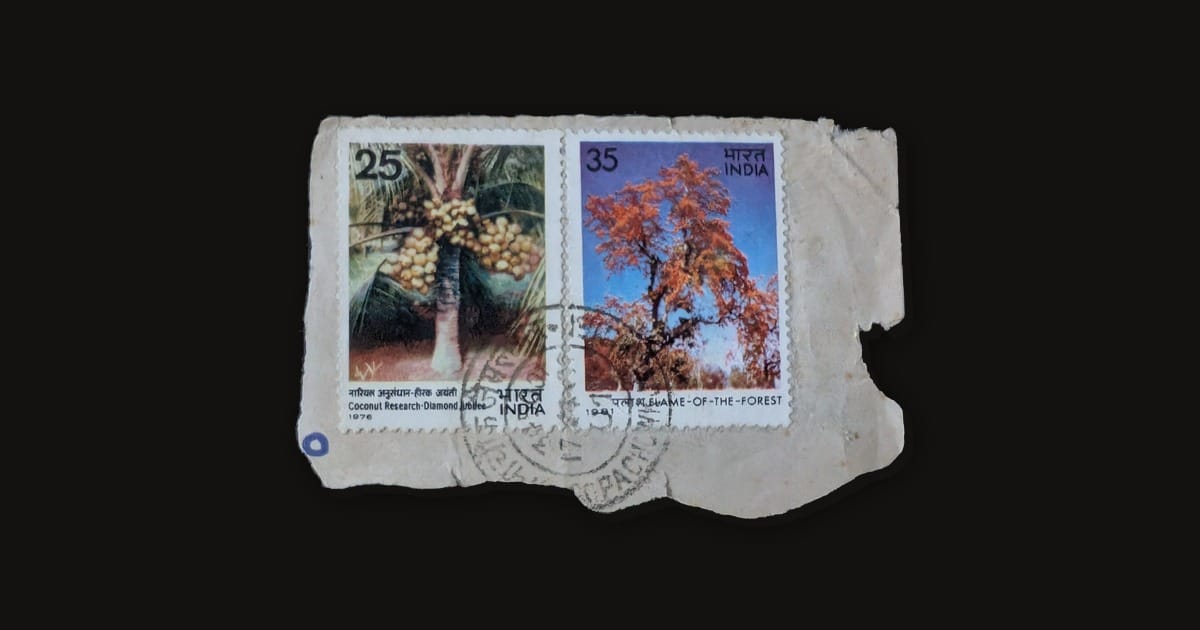 Two used Indian stamps on a torn envelope corner, the 25 paise Coconut Research palm of 1976 beside the 35 paise Flame of the Forest tree of 1981, tied by one circular postmark