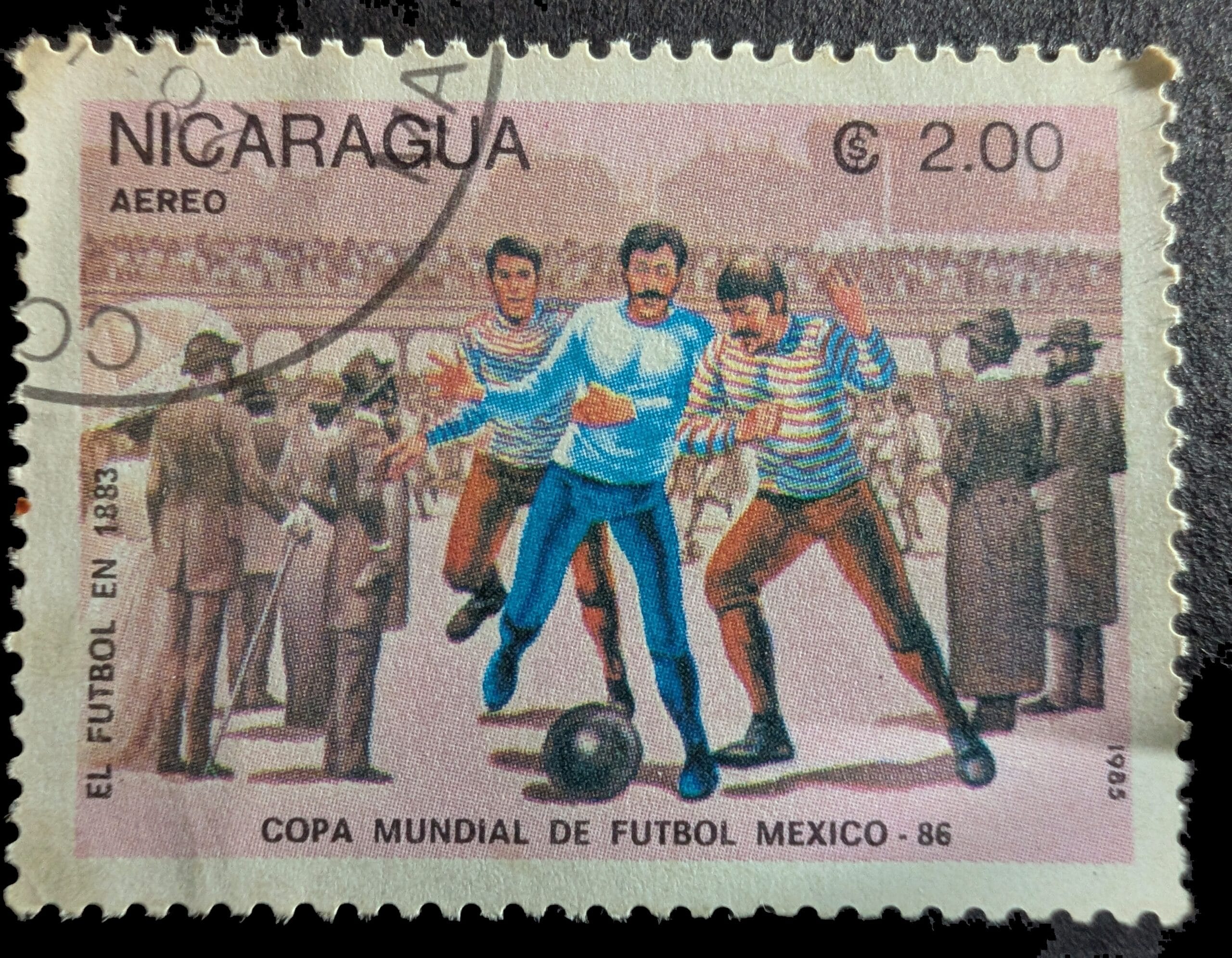 1883 FA Cup Final scene on the 1985 Nicaragua El Futbol en 1883 stamp, 2 córdobas airmail — three players contesting a heavy dark ball before a crowd in top hats and long coats
