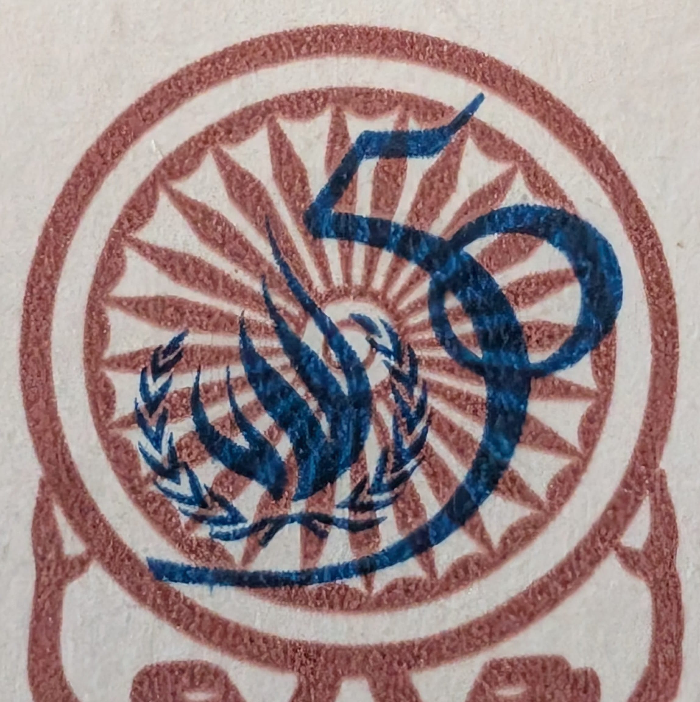 Macro of the blue 50 anniversary emblem printed over the red-brown spoked chakra at the centre of the 1998 India Universal Declaration of Human Rights stamp
