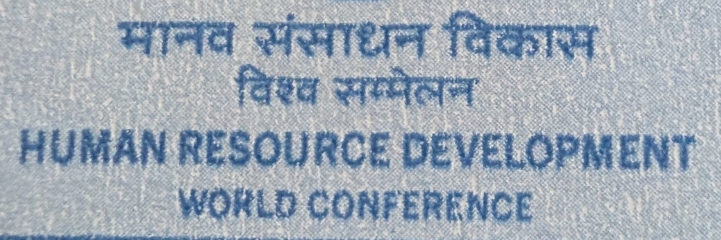 Macro of the bilingual caption reading मानव संसाधन विकास विश्व सम्मेलन above HUMAN RESOURCE DEVELOPMENT WORLD CONFERENCE on the 1994 India stamp