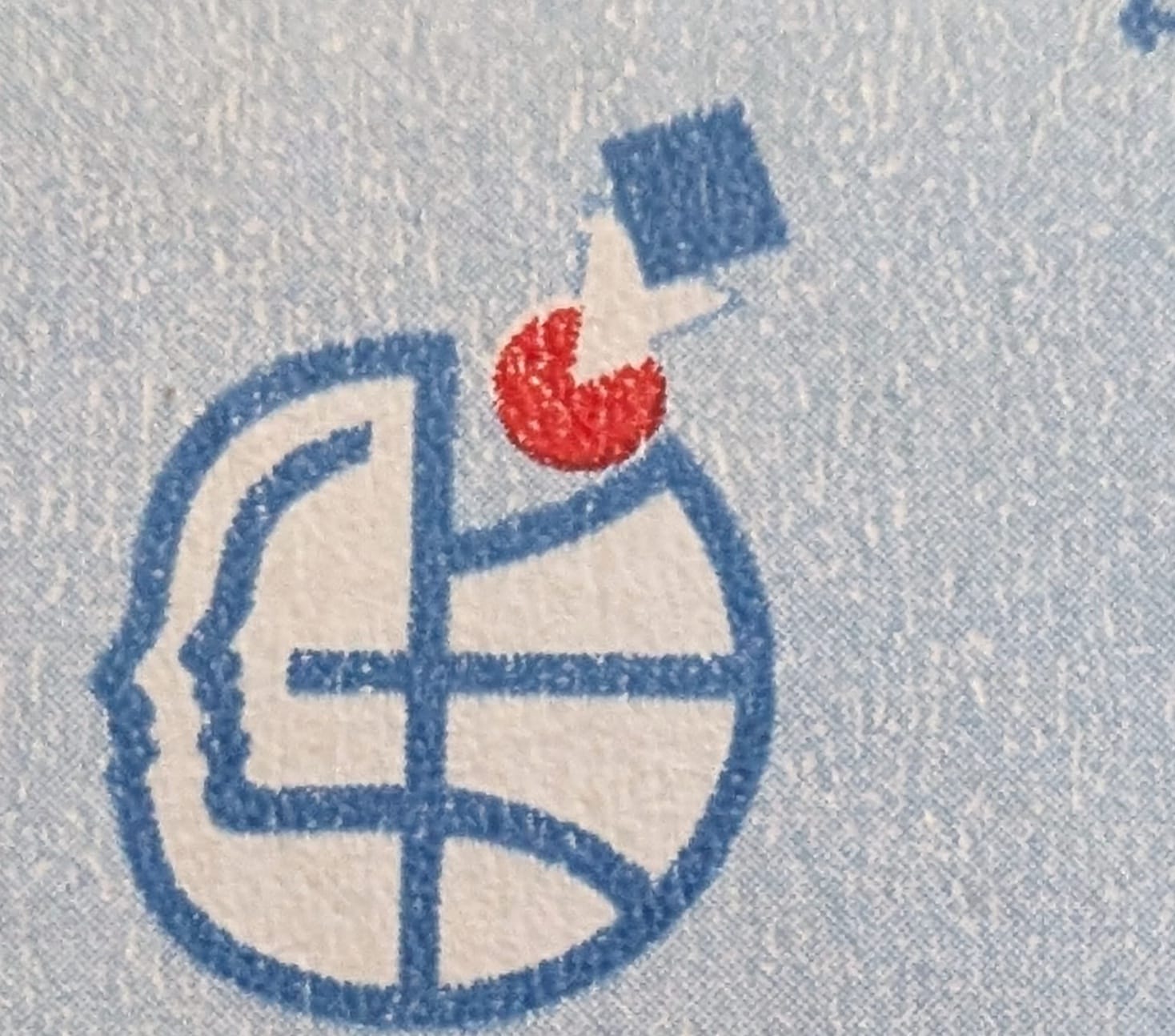 Macro of the blue conference emblem on the 1994 India stamp, a human head in left profile fused with a gridded globe, a red disc and a small square above