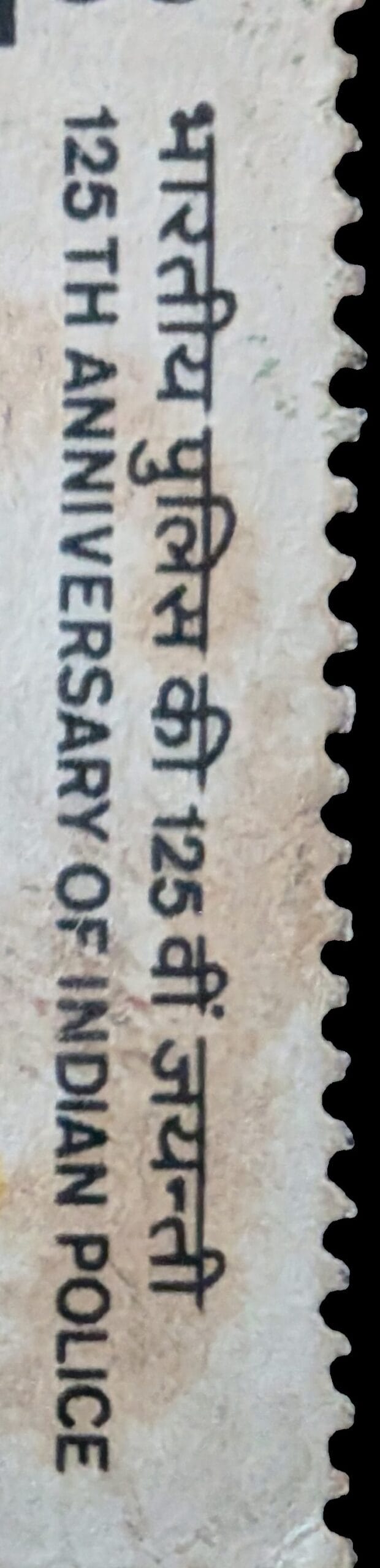 Macro of the bilingual inscription band reading भारतीय पुलिस की 125वीं जयंती above 125TH ANNIVERSARY OF INDIAN POLICE on the 1986 India stamp