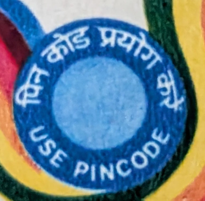 Macro of the central blue roundel on the 1989 Use Pincode stamp reading pin code prayog karein in Hindi and USE PINCODE in English