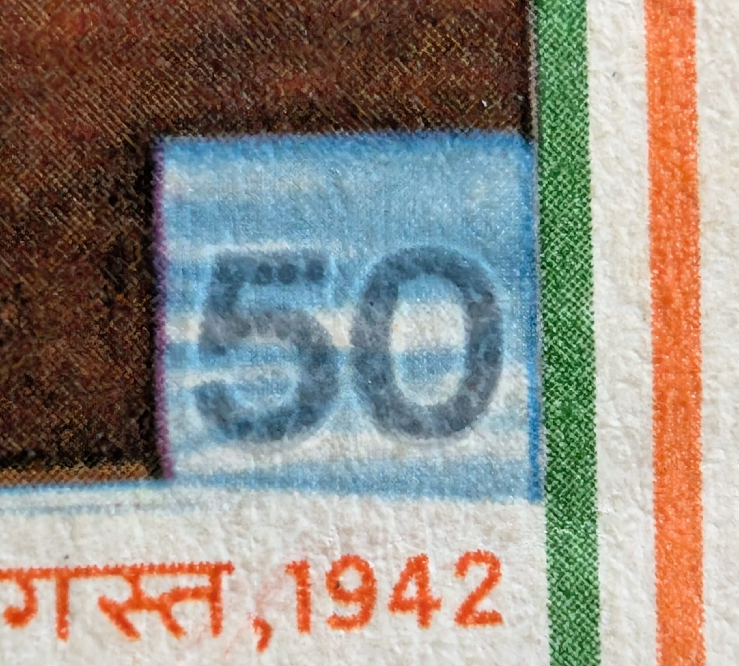 The pale blue 50 paise denomination and the heavy condition crease running through the lower right corner of the Quit India Resolution stamp 1983