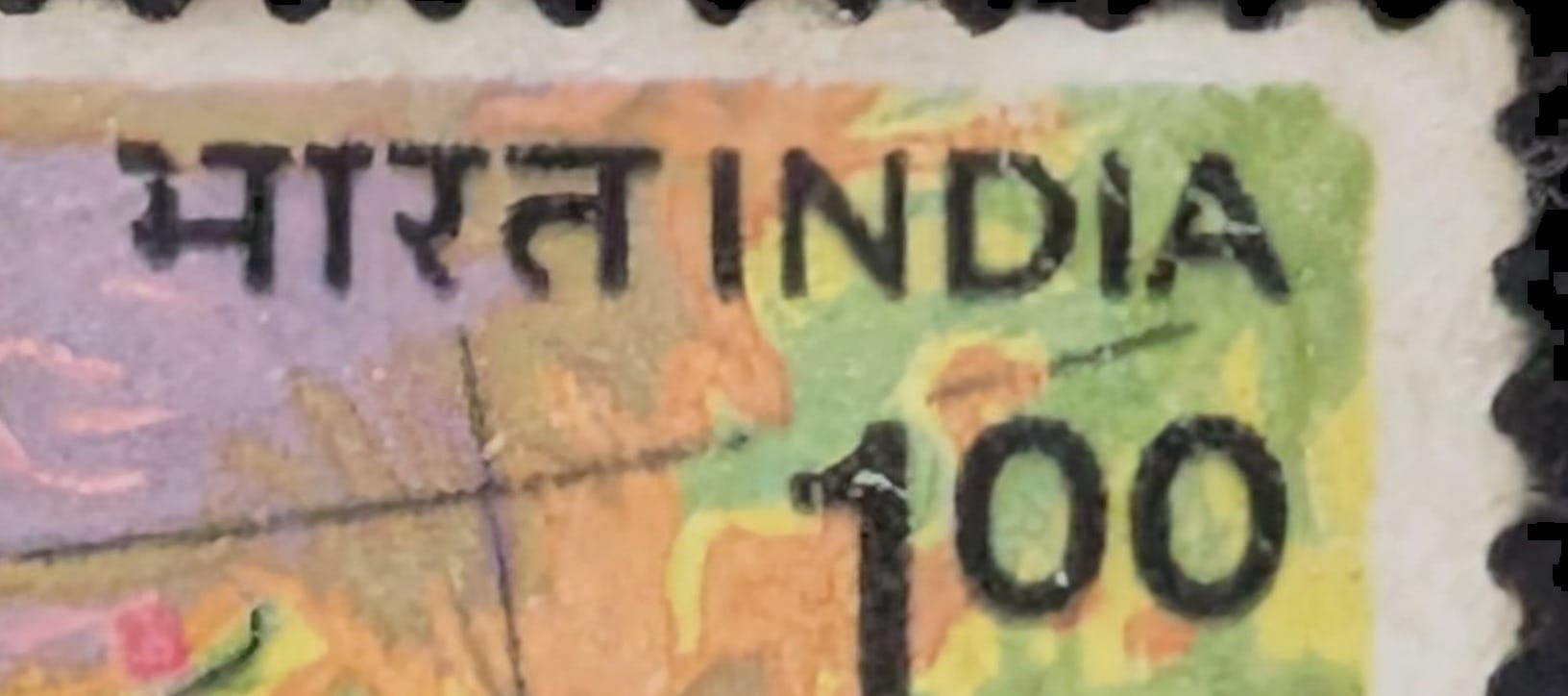 Macro of the top-right corner of the 1985 India stamp showing the भारत India inscription and the 100-paise value tucked into the corner while the map fills the rest of the frame