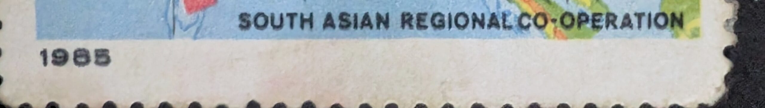 Macro of the lower band of the 1985 India stamp reading SOUTH ASIAN REGIONAL CO-OPERATION with the year 1985 at the corner