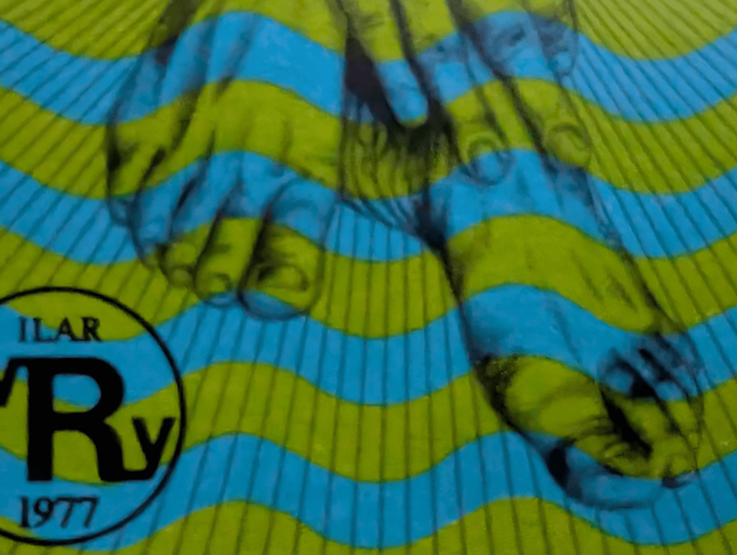 Macro of the lower ghosted hands on the World Rheumatism Year stamp, printed through blue and green wave bands so the fingers seem to sink into striped water