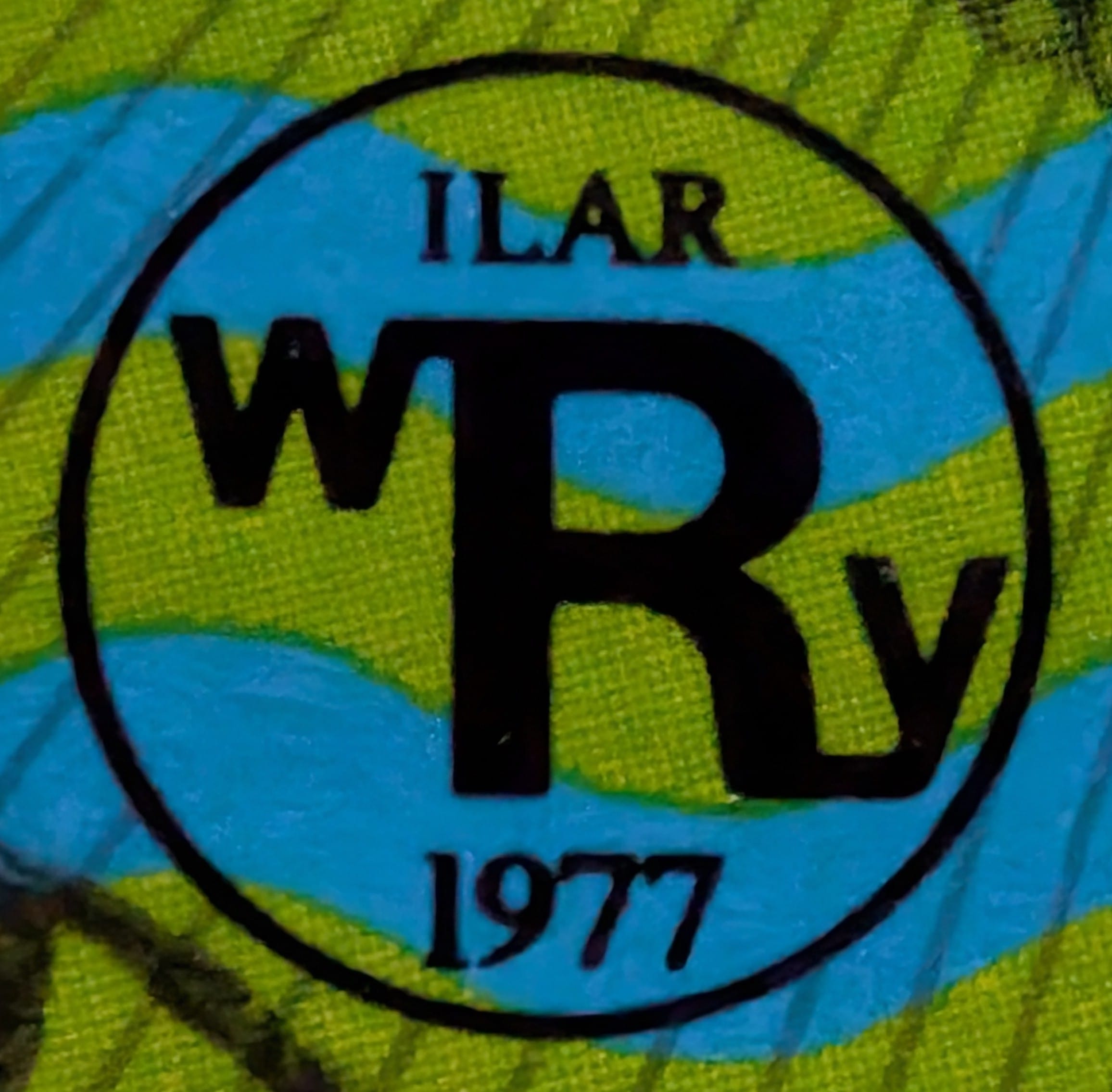 Macro of the circular ILAR / WRy / 1977 emblem on Hungary's World Rheumatism Year stamp, the mark of the international rheumatology campaign behind the issue